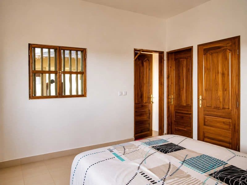 Intérieur d'une case de la Casa Star : murs blancs, portes et fenêtre en bois
